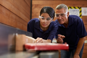 Young woman and older man with safety glasses testing something